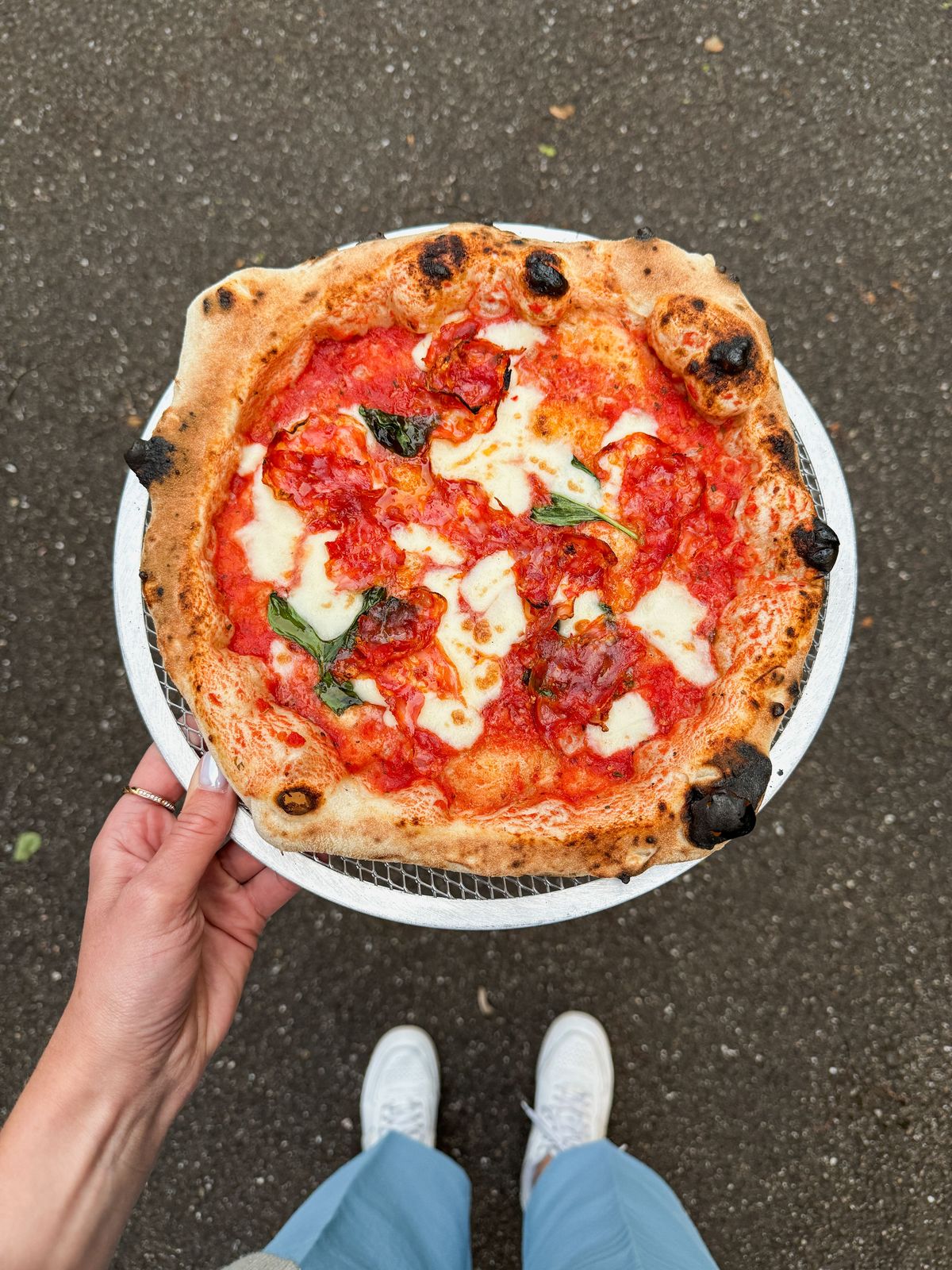 Pizza napolitaine tenue à la main